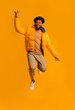© Prostock-studio - Excited afro man in bright winter jacket jumping up