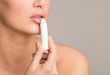 © Prostock-studio - Woman applying hygienic balm to her plump lips