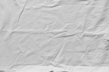 Crumpled white clean cotton texture. Wrinkled textile background, top view. Fabric shirt, close-up