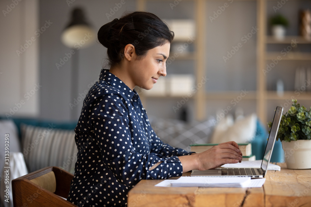 Indian girl using laptop study in internet sit at table - obrazy, fototapety, plakaty 