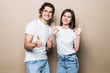 © F8  \ Suport Ukraine - Portrait of beautiful people man and woman in basic clothing posing together at camera with thumbs up isolated over beige background