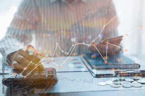 Cuadros en Lienzo Double exposure of Businessman working on desk office with Investors are calculating on calculator investment costs, His business growth and progress