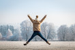 © encierro - Happy woman jumping with arms outstretched in winter nature