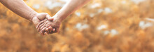 Loving Senior Couple Holding Hands Together Over Nature Background.