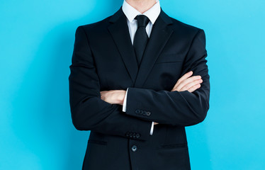 Businessman crossing his arms on blue background