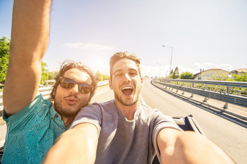 Wall Mural - Happy friends taking a selfie at car trip - Two caucasian tourist travelling around the world