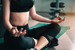 © Take Production - fitness ,workout, gym exercise ,lifestyle  and healthy concept. Women practice yoga sitting posture, meditation, stretching at the indoor gym for good health at sunset. Side view image
