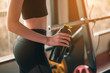 © Take Production - fitness ,workout, gym exercise ,lifestyle  and healthy concept. Close-up side view of a woman holding a protein shake bottle after a workout is done to relax and unwind at the indoor gym at sunset.