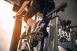 © Take Production - fitness ,workout, gym exercise ,lifestyle  and healthy concept. Woman exercise working out in the gym for healthy lifestyle on bike at sunset.