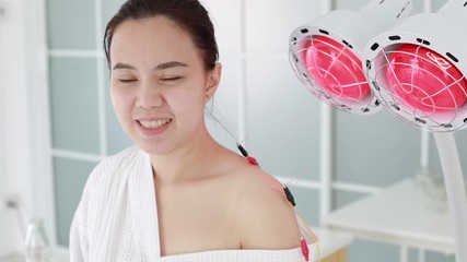 Wall Mural - hand of doctor performing acupuncture therapy . Asian female undergoing acupuncture treatment with a line of fine needles inserted into the her body skin in clinic hospital