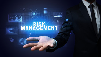 Hand of Businessman holding RISK MANAGEMENT inscription, business success concept