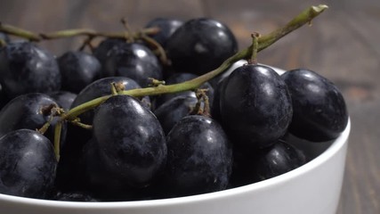 Wall Mural - Uvas negras en un bol en la mesa, detalle