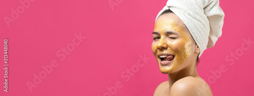 Fotografía Beauty portrait of woman in white towel on head with gold nourishing mask on face