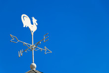 White Rooster Weather Vane Show The Wind Direction On Blue Sky Background