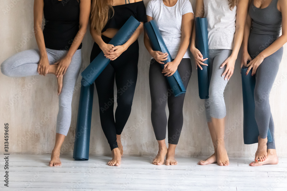 Group diverse sporty women with yoga mats standing in gym - obrazy, fototapety, plakaty 