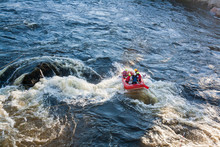 A Group Of Men And Women White Water Rafting On A River As Extreme And Fun Sport