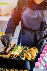 Wall Mural - Hands in black gloves serves sandwiches. Catering