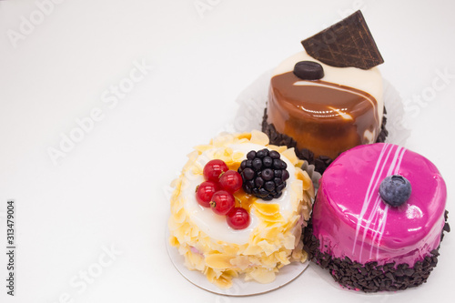 Fotografía Three cakes on a white background:coffee cake with a grain of coffee, chocolate,