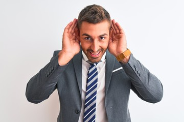 Canvas Print - Young handsome business man wearing suit and tie over isolated background Trying to hear both hands on ear gesture, curious for gossip. Hearing problem, deaf