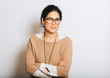 © annanahabed - Studio portrait of beautiful brunette woman, wearing glasses, arms crossed, posing on white background