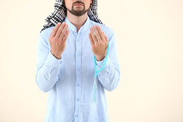 Wall Mural - Muslim man praying against light background