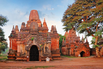 Blue sky above temples surrounded by green vegetation in old Bagan, Myanmar.