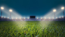 Soccer Stadium With Green Grass Field With Bright Floodlight Background.lights At Night And Football Stadium