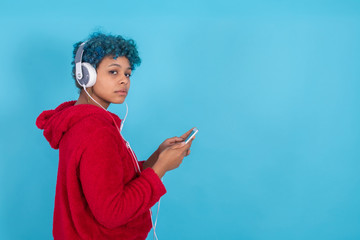 Wall Mural - young girl or woman with mobile phone and headphones with space for text or ads