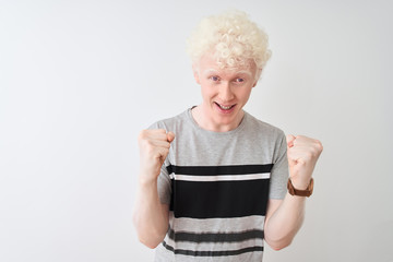 Wall Mural - Young albino blond man wearing casual t-shirt standing over isolated white background celebrating surprised and amazed for success with arms raised and open eyes. Winner concept.