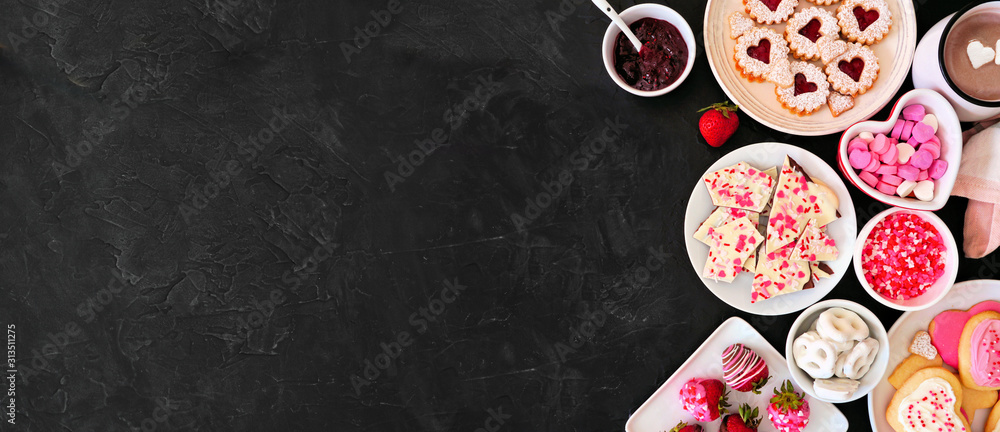 Valentines Day side border banner with a selection of sweets and cookies. Top view over a dark stone background. Love and hearts theme. Copy space. - obrazy, fototapety, plakaty 