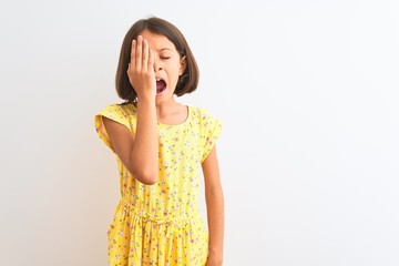 Sticker - Young beautiful child girl wearing yellow floral dress standing over isolated white background Yawning tired covering half face, eye and mouth with hand. Face hurts in pain.