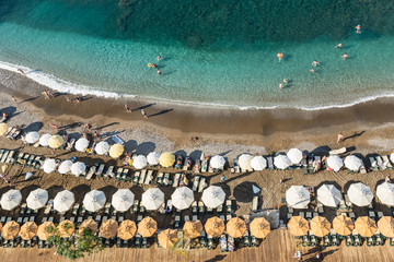 Turkish beach filled with holidaymakers, rows of sun loungers and parasols