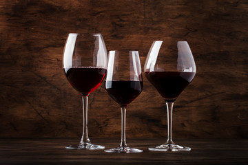 Wine glass. Selection of red wines on wine tasting. Dry, semi-dry, sweet red wine on old wooden table background. Copy space