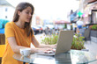 © ty - Smiling woman using laptop in cafe. Concept of entrepreneur, businesswoman, freelance worker.