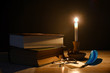© balenabianca - Vecchi libri illuminati dalla fiamma della candela