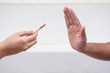 © 9nong - man hand trying to quit smoking by rejecting cigarette offer, saying no to cigarette smoke; concept of stop smoking, smoking ban or no smoking here