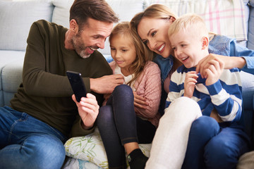 Wall Mural - Family using mobile phone in living room