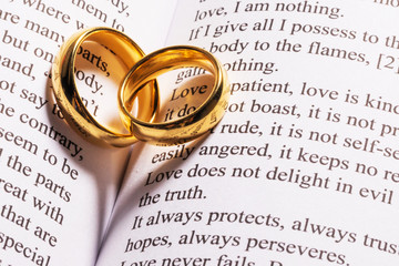 golden wedding rings on bible book