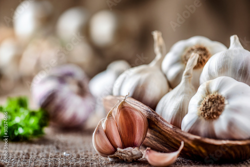 Cuadros en Lienzo Garlic clove and bulbs in wooden bowl