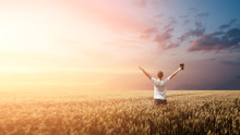 Man Holding Up Bible In A Wheat Field During Sunrise. Panoramic Shot