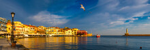 Old Port Of Chania With Flying Seagulls. Landmarks Of Crete Island. Bay Of Chania At Sunny Summer Day, Crete Greece. View Of The Old Port Of Chania, Crete, Greece. The Port Of Chania, Or Hania.