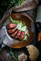 Cooked fillet of beef tenderloin sliced on a plate with an Italian salad. Barbecue dry aged wagyu sirloin beef steak