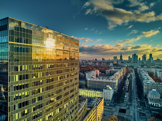 Wall Mural - Beautiful panoramic aerial drone view to the Сenter of modern Warsaw city with silhouettes of skyscrapers in in the rays of the setting winter January sun - amazing sunset, Poland