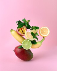 Conceptual and creative composition of exotic fruits on a pink background