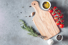 Wooden Cutting Board With Fresh Herbs And Raw Vegetables On Rustic Wood Table. Top View. Cooking Background.