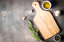 Wooden Cutting Board With Fresh Herbs And Raw Vegetables On Rustic Wood Table. Top View. Cooking Background.