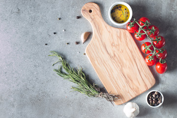 Wooden Cutting Board with Fresh Herbs and Raw Vegetables on Rustic Wood Table. Top view. Cooking background.