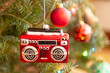 A christmas ornament in the shape of a radio or boom box hanging on the Christmas tree. Texture added.