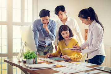 Wall Mural - group of young asian designers drawing website ux app development on mobile phone.