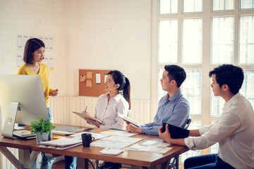 Wall Mural - group of young asian designers drawing website ux app development on mobile phone.